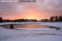 aurinko-laskee-lumisella-golfkentalla